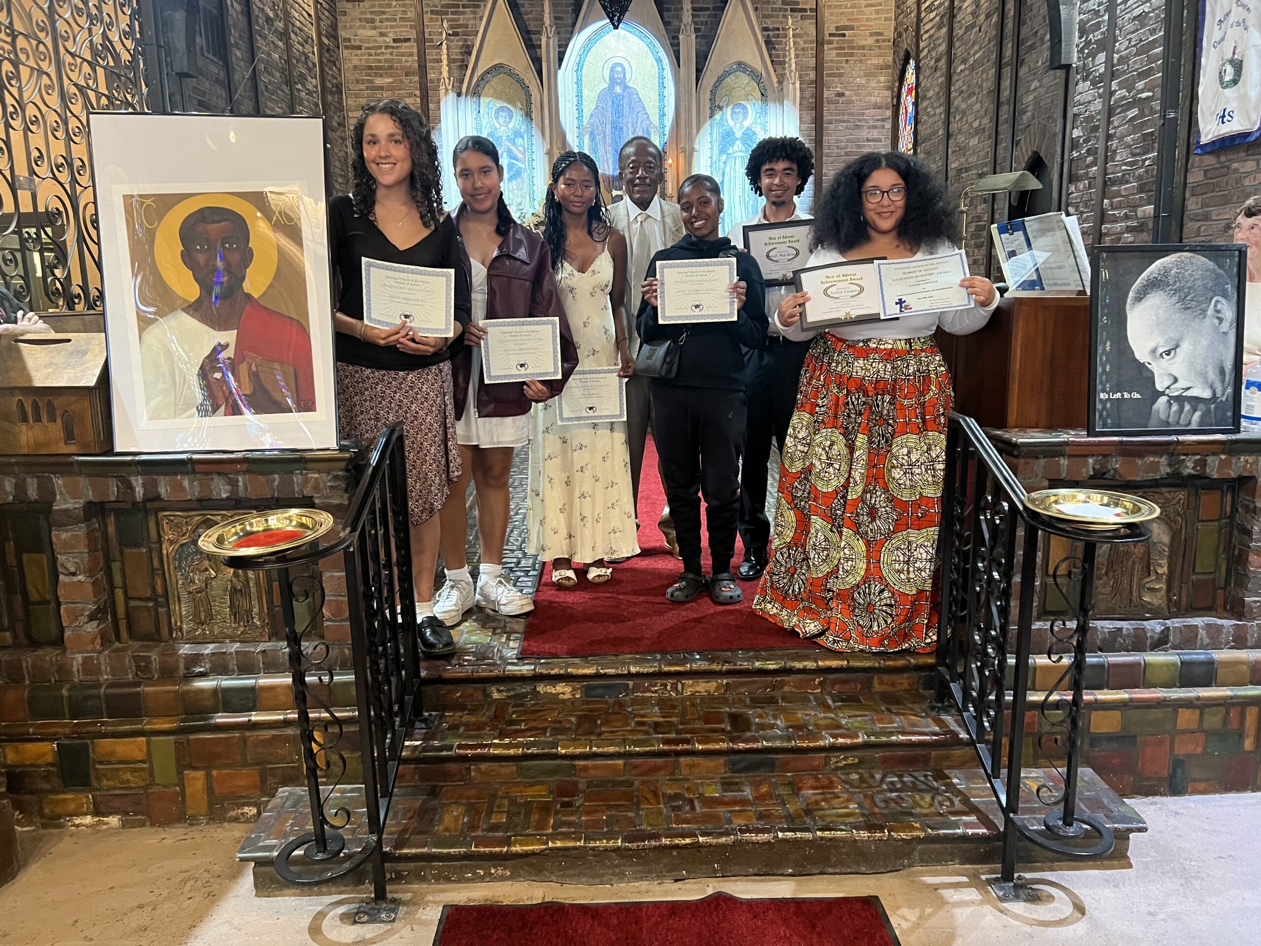 Photo of scholarship recipients in church holding certificates.